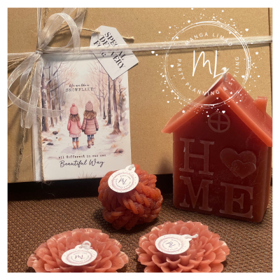 Velas decorativas cor de rosa e vermelha com embalagem de presente e cartão ilustrado em fundo castanho