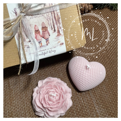 Caixa de presente com cartão de inverno e duas velas rosas, uma em forma de flor e outra em forma de coração.