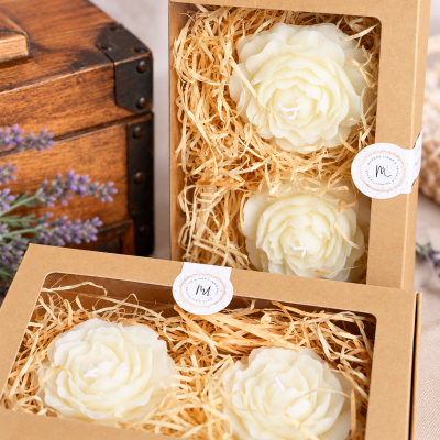 Caixas de velas em forma de rosa brancas em embalagens de cartão com palha decorativa