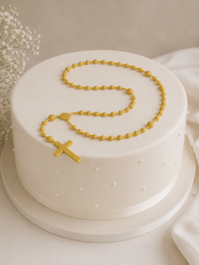 Bolo redondo branco com decoração de pérolas e terço amarelo por cima