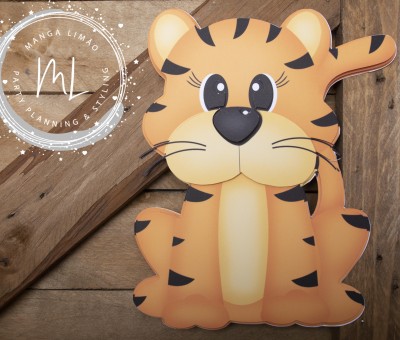 Decoração laranja em forma de tigre com manchas pretas e olhos grandes sobre fundo de madeira