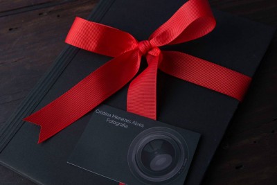 Livro preto com fita vermelha e cartão de fotografia preto
