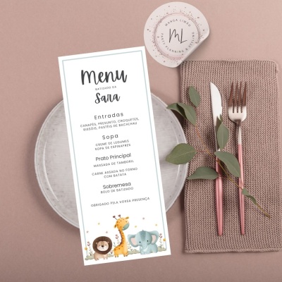 Mesa posta com prato cinza claro, menu branco infantil, guardanapo castanho tricotado e talheres cor de cobre