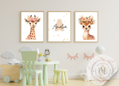 Três quadros infantis com girafa, nome Amélia e veado em molduras de madeira, acima de mesa e cadeiras verdes claras