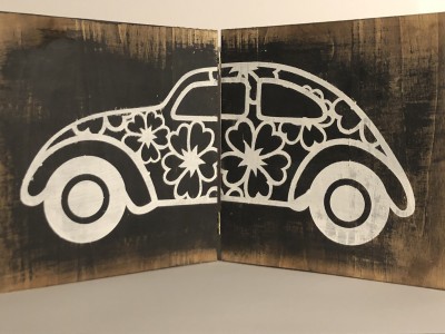 Desenho branco de carro clássico com flores em duas placas de madeira escuras