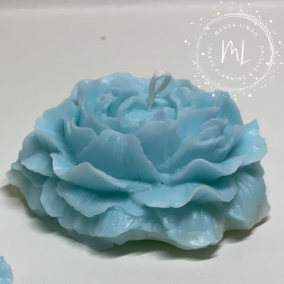 Vela azul em forma de flor com pavio branco em fundo branco