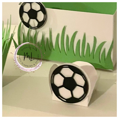 Caixas pequenas brancas com bolas de futebol em preto e branco e decoração verde de relva