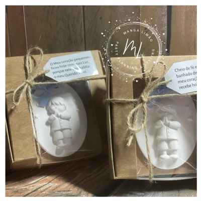 Sabonetes brancos ovais com figura em relevo embalados em caixas kraft com fita rústica