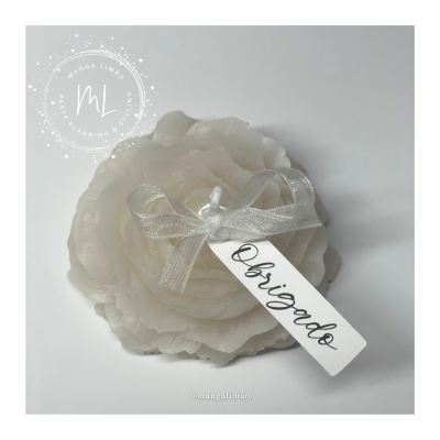 Vela decorativa em forma de flor creme com etiqueta 'Obrigado'