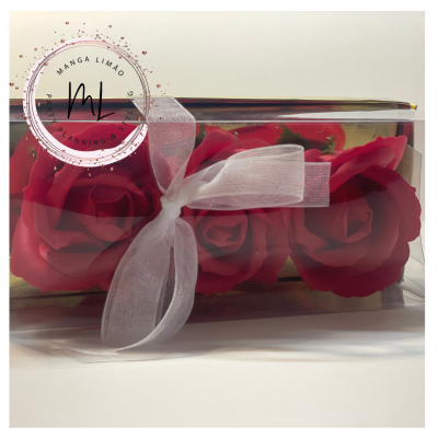 Arranjo de flores vermelhas em caixa transparente com fita branca