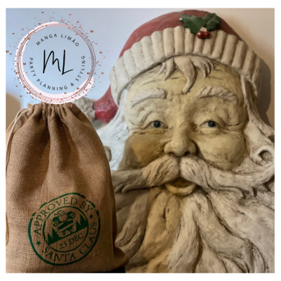 Saco de tecido com carimbo de aprovação do Pai Natal ao lado de escultura do rosto do Pai Natal