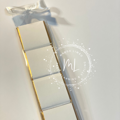 Barra de chocolate branca embalada com fita branca e bordas douradas