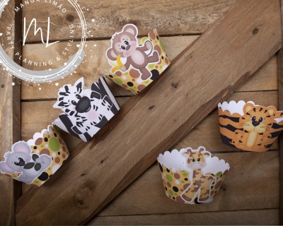 Formas de papel para muffins com desenhos de animais da selva sobre madeira