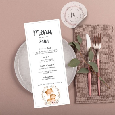 Menu em português sobre prato cinza com talheres rosas, guardanapo cinza e copo com etiqueta ML.