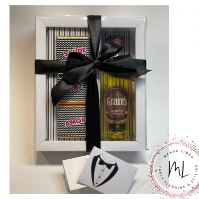 Conjunto de whisky e chocolates em caixa branca com fita preta.