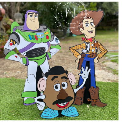 Figuras de personagens Toy Story em tamanho real num cenário exterior com relva artificial.