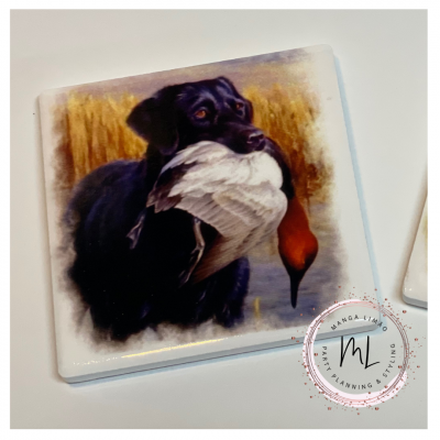 Azulejo quadrado com imagem de cão labrador a segurar pato, com paisagem natural ao fundo