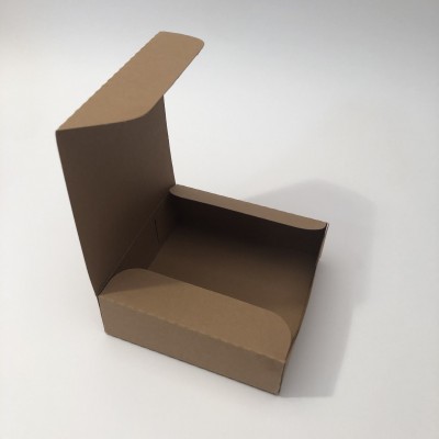 Caixa de cartão castanho aberta sobre superfície branca