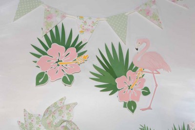 Decoração de parede com flores tropicais cor-de-rosa, folhas verdes e um flamingo rosa