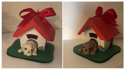Duas casinhas de cão decorativas com cães em resina e fitas vermelhas no topo