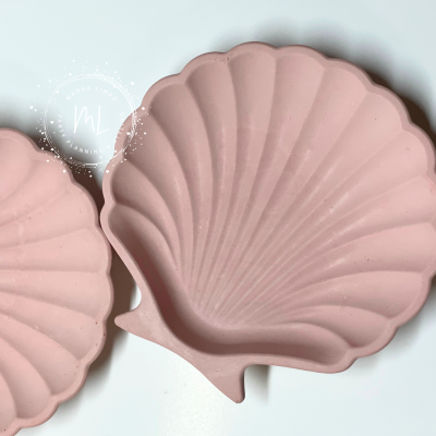 Prato decorativo rosa em forma de concha com textura de ranhuras.