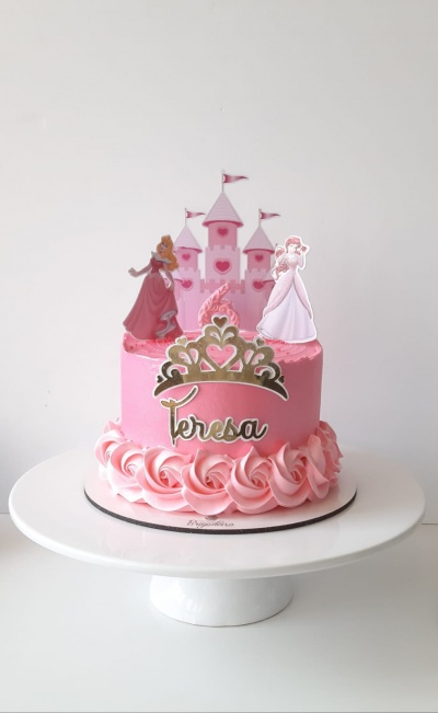 Bolo rosa decorado com figuras de princesas e castelo