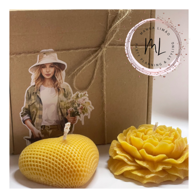 Duas velas amarelas decorativas e caixa de papelão com laço de corda