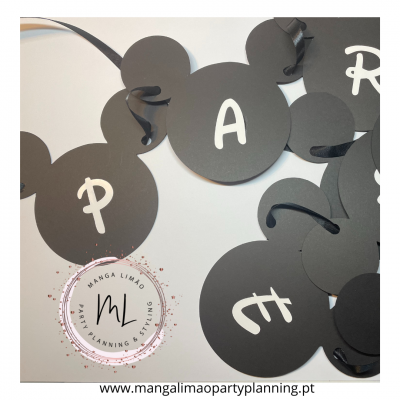 Peças decorativas pretas em forma de cabeça do Mickey Mouse com letras brancas e fitas pretas
