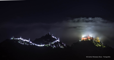 castelo iluminado à noite no topo de colinas