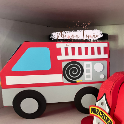 Caixa formato carro de bombeiros vermelho com detalhes cinza e azul numa prateleira