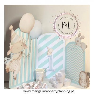 Decoração de festa infantil com painéis azul e branco, ovelha, coelho e número 1.