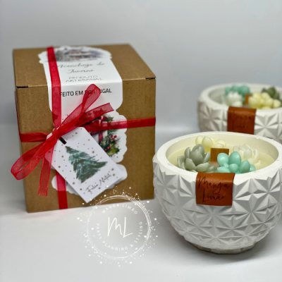 Vela decorativa em vaso branco com flores de cera e caixa com laço vermelho