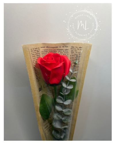 Rosa vermelha artificial com folhas em papel de jornal