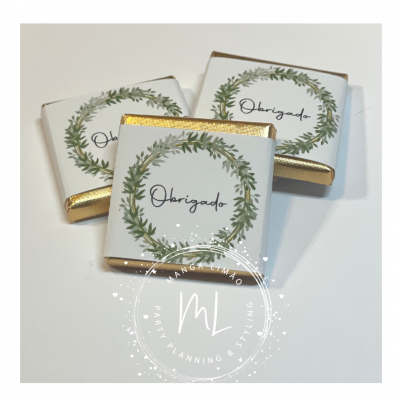 Três chocolates embrulhados com etiqueta 'Obrigado' e coroa de folhas verdes