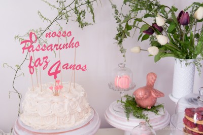 Bolo branco decorado com uma frase em acrílico vermelho, flores e decoração de passarinho