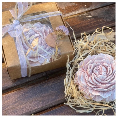 Flor decorativa cor de rosa com caixa de presente e fita branca sobre madeira