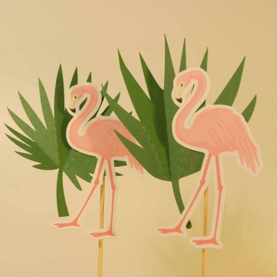 Dois flamingos cor-de-rosa recortados com folhas verdes ao fundo