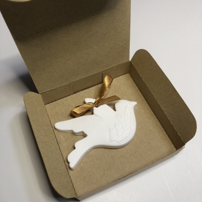 Decoração em forma de pomba branca com relevo em caixa de papelão castanho
