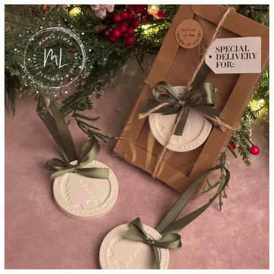 Enfeites de Natal brancos redondos com fitas verdes e embalagem com etiquetas em fundo com guirlanda