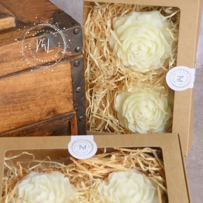 Caixas castanhas com flores brancas decorativas em palha amarela e autocolantes com logo ML