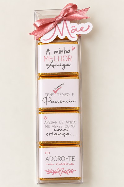 Conjunto de chocolates com mensagens para mãe, embrulhados em papel branco com texto, em caixa transparente com laço rosa.