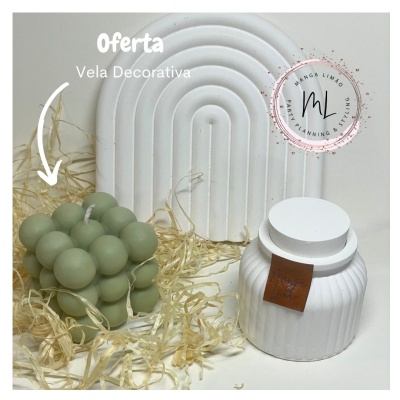Vela decorativa verde em forma de cubo com bolhas, recipiente branco, e objeto decorativo branco ao fundo