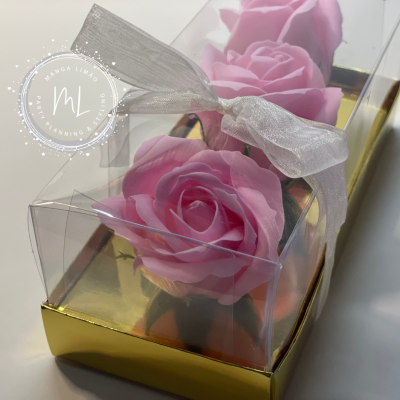 Caixa transparente com três rosas cor-de-rosa e fita branca