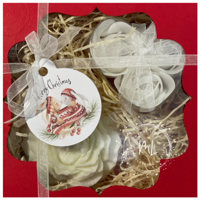 Flores decorativas brancas em caixa vermelha com laço e etiqueta de Natal