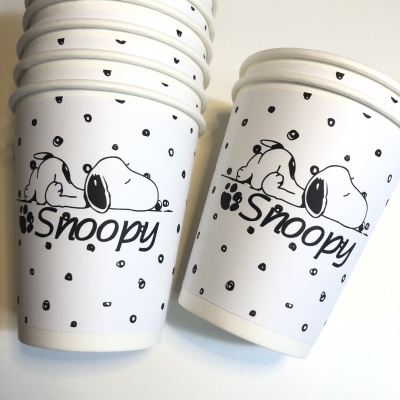 Copos de papel brancos com ilustração do Snoopy e texto 