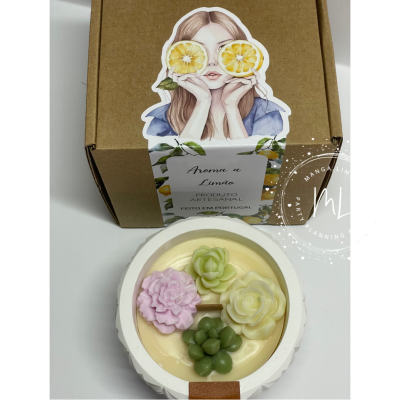 Vela decorativa com flores de cera e embalagem com rótulo de aroma a limão