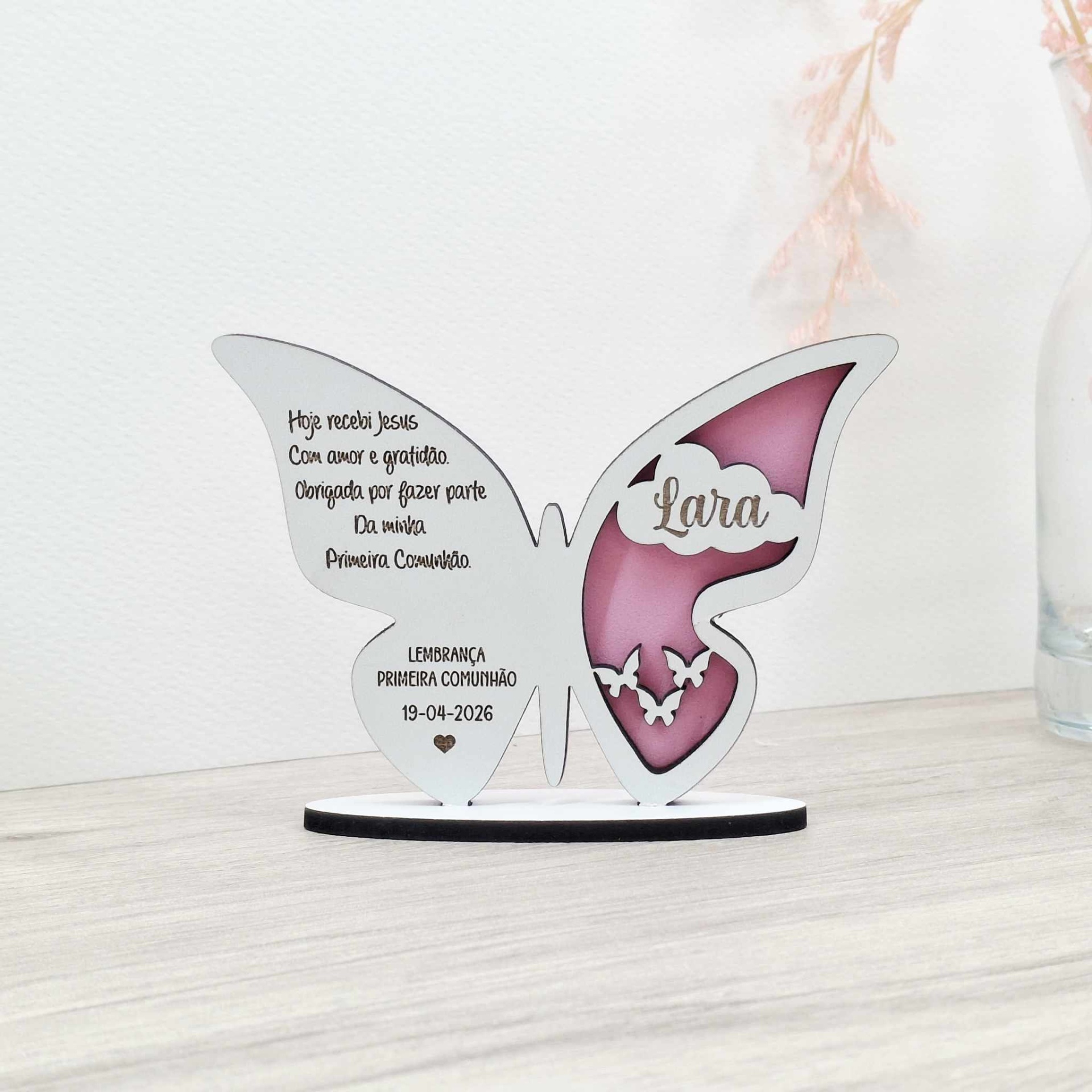 Lembrança borboleta com base Peça decorativa borboleta branca e rosa com texto de primeira comunhão e nome Lara em fundo branco