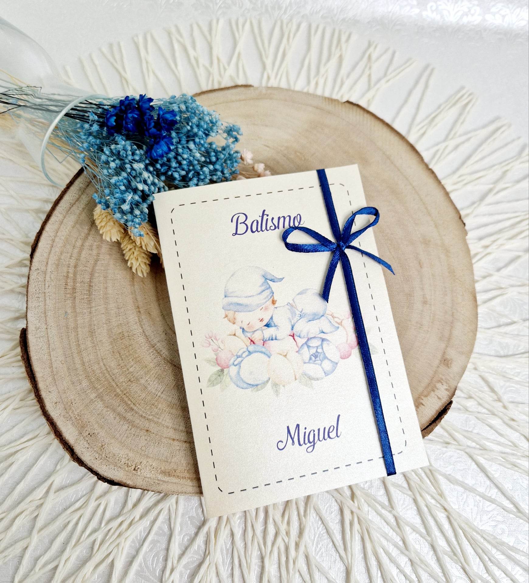 Convite Bebé - Menino Convite de batismo com ilustração de bebê e fita azul sobre madeira redonda