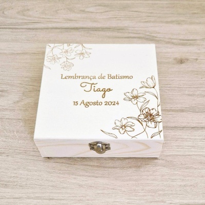 Caixa branca de madeira com texto dourado e flores decorativas para batismo