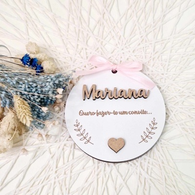 Etiqueta redonda branca com nome Mariana e laço rosa, junto a flores secas azuis e brancas